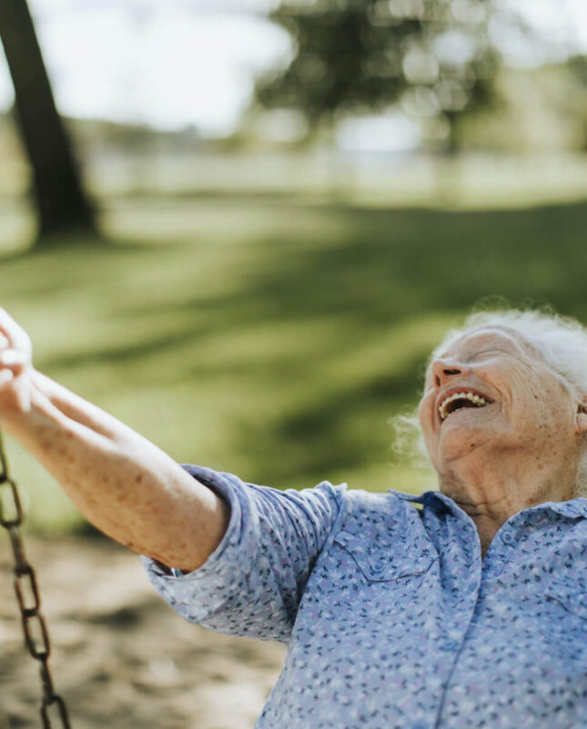 Senior woman smiling on swing