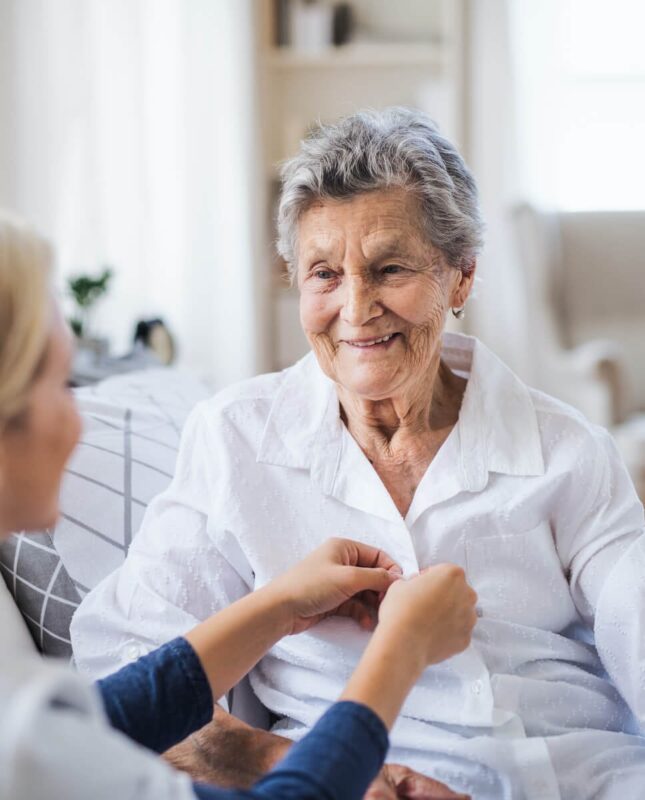 Senior Living Memory Care resident getting nurse assistance with dressing