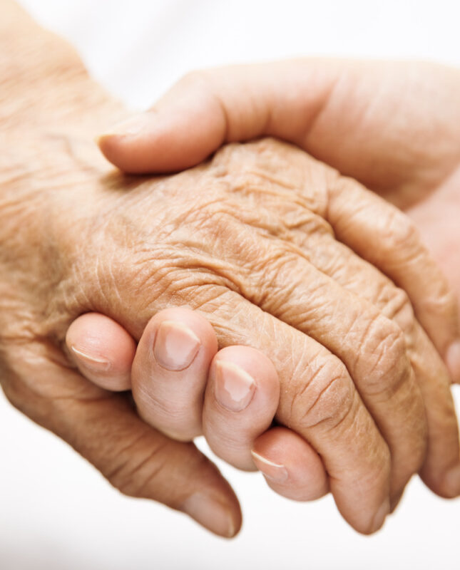 Memory care community adult helping senior in hospital